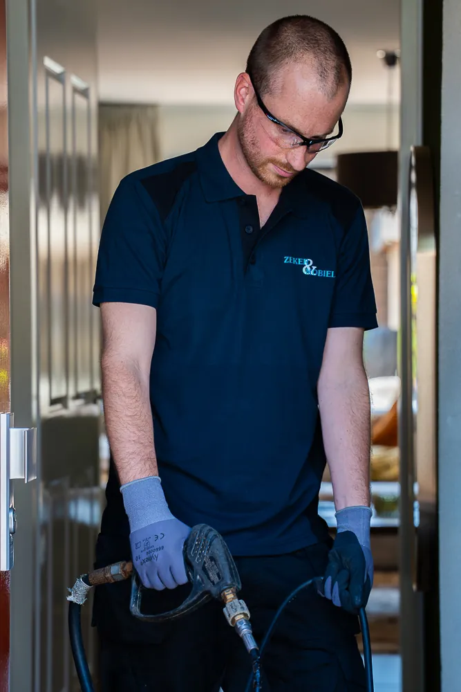Monteur van Zeker & Mobiel met een hogedrukreiniger in de deuropening van een woning in Drachten