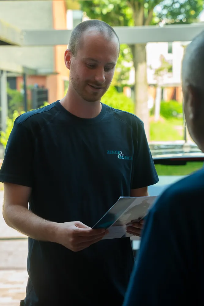Zeker & Mobiel-monteur bespreekt het Servicecontract voor ontstopping met een klant aan tafel