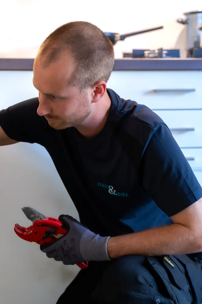 Monteur van Zeker & Mobiel met gereedschap bij de verstopte wasbak