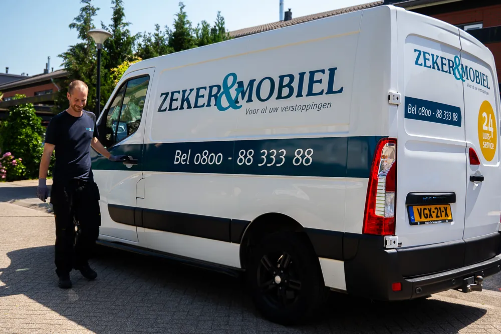 Ontstoppingsbedrijf Zeker & Mobiel in Emmen: monteur bij de bedrijfsbus met het gratis nummer