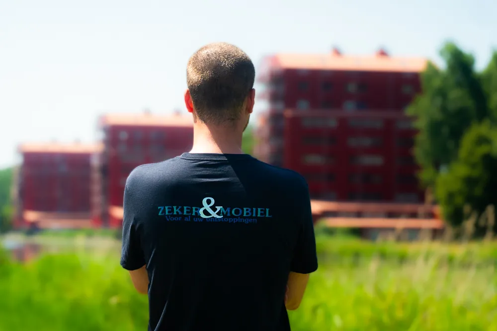 Monteur van Zeker & Mobiel van achteren met het bedrijfslogo op de werkkleding