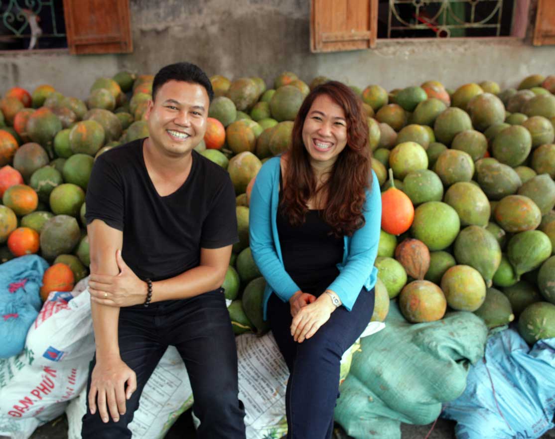 Vietnamees ondernemerspaar bij hun marktstand, mogelijk gemaakt door microkrediet van Oxfam Novib